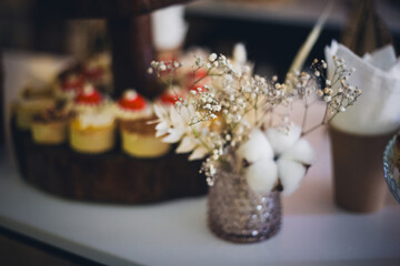 Delicate floral arrangement complements a display of sweet mini cheesecakes with red topping
