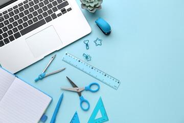 Set of school stationery with laptop and houseplant on blue background