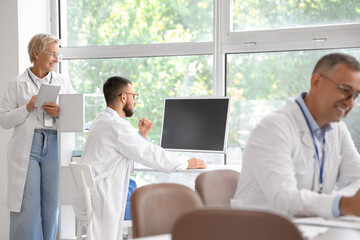 Doctors working with computer at table in clinic
