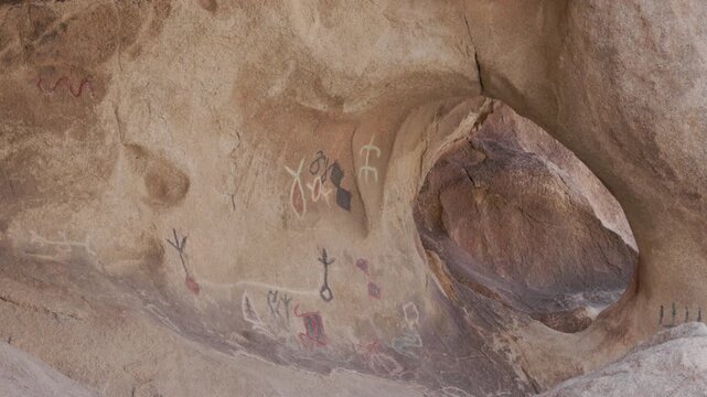 a shot of american indian pictographs and an arch inside a cave at joshua tree national park in california, usa