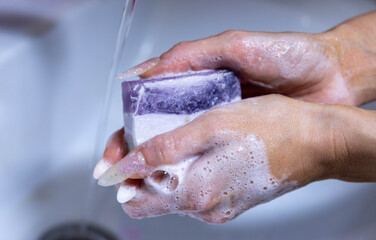 Fototapeta premium girl washing hands with soap in sink closeup