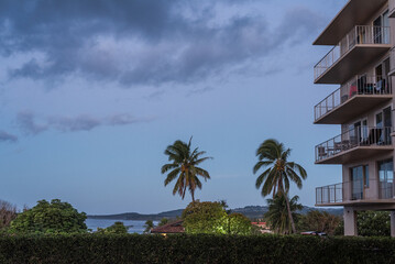 Obraz premium Tropical hotel balconies and palm trees at dusk