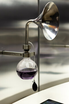 matraces con sustancia morada, aroma, embudo, laboratorio qu&iacute;mico con reflejos en la pared, experimentacion