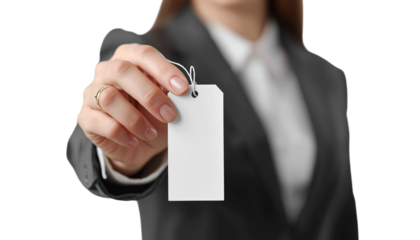 A woman in a business suit holding a blank white tag for labeling or identification on
