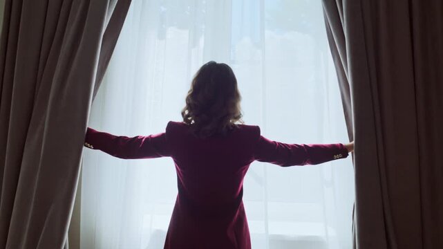 Happy girl opening drapes illuminating modern hotel room closeup. Smiling woman