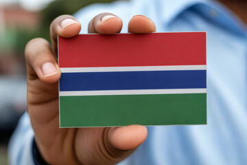 Hand proudly presents The Gambia flag, symbolizing national pride and cultural heritage of the vibrant West African nation
