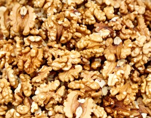 Obraz premium Close-up view of a pile of raw, shelled walnuts. The image showcases the detailed texture and varied shapes of the nut halves