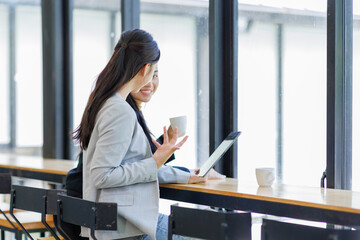 Two business working together using digital tablet pc and talking about a business project. Small creative diversity team of females executives meeting work in office.
