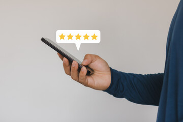 Customer satisfaction concept with five star rating on smartphone. Hand holding mobile phone showing online review, feedback, user experience, service quality, digital marketing, business reputation.