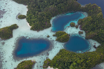 Rugged rock islands, composed of ancient, uplifted reefs, rise from the seascape in Misool, Indonesia. This region harbors spectacular marine biological diversity and is a popular destination for dive