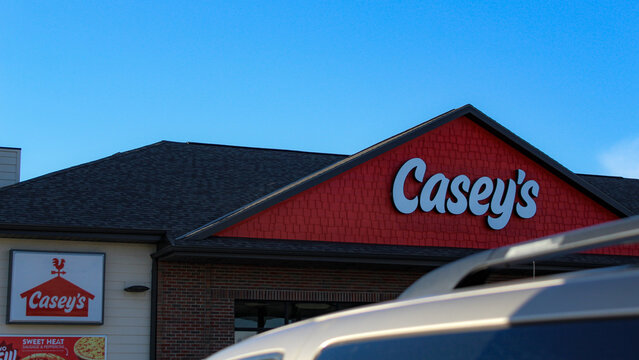 A Casey's convenience store sign seen above a vehicle by a gas pump. The company is a major chain in the Midwestern and Southern United States (Queen City, MO - Dec. 23, 2025). Editorial Use Only.