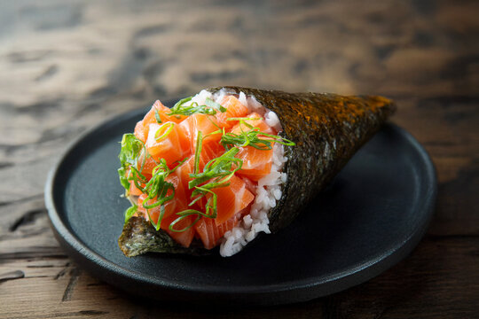 salmon temaki. shari rice, nori, raw salmon and chives