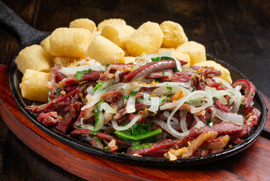Dried beef with onions and fried cassava. A traditional snack in Brazilian bars.Cassava with dried beef