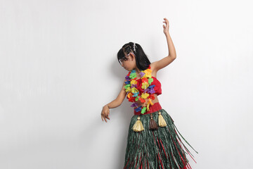 5-year-old Latina girl with brown hair enjoys learning to dance Hawaiian, wearing a colorful skirt and leis, and shows off her moves © Arlette