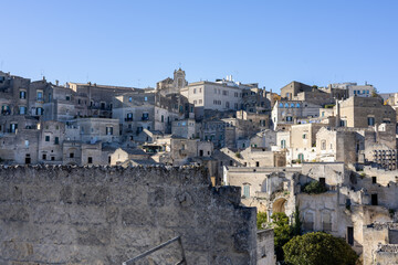 panoramic view of ancient sassi di matera buildings under a clear blue sky. historic stone architecture of the unesco world heritage site in basilicata, italy.
