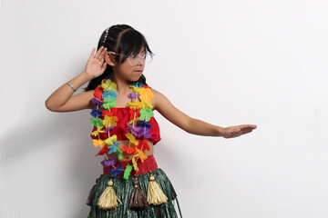 5-year-old Latina girl with brown hair enjoys learning to dance Hawaiian, wearing a colorful skirt and leis, and shows off her moves © Arlette