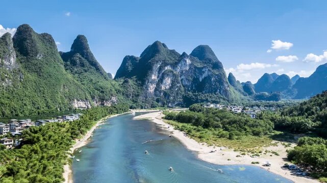 aerial time-lapse of Li River&rsquo;s Nine Horse Fresco Hill in Yangshuo, Guilin&mdash;iconic karst peaks, bamboo rafts, and traditional villages under a bright sky, China