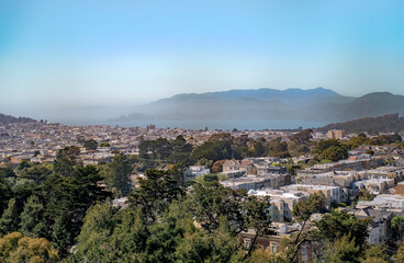 Fototapeta premium Fog rolls in on a sunny day in San Francisco. The fog comes to the city on a sunny day. San Francisco, California, United States of America