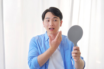 鏡を見る男性　20代　美容
