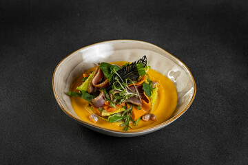Pumpkin salad with dried duck, cherry tomatoes and pumpkin seeds. Close-up, selective focus