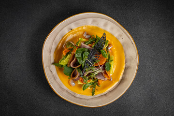 Pumpkin salad with dried duck, cherry tomatoes and pumpkin seeds. Close-up, selective focus