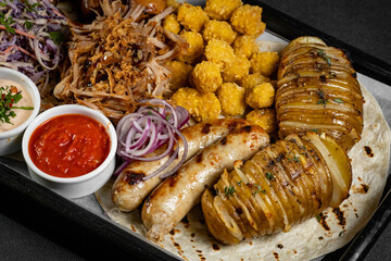 Delicious grilled meat platter with various sauces served on a wooden board, perfect for sharing with friends and family
