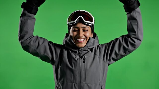 Joyful woman athlete celebrates her win, raising her arms in a close-up shot against the vibrant green screen.