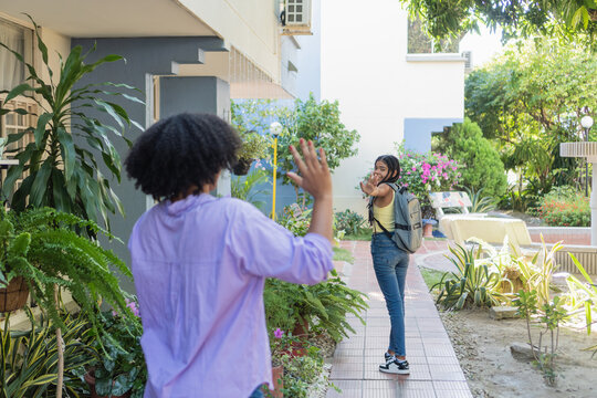 Mother and daughter waving goodbye for school day