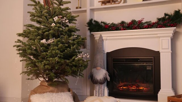 Beautiful Christmas tree and decorative gnome near fireplace at home