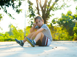 Portrait of exhausted young girl resting on the ground after sports activity.
