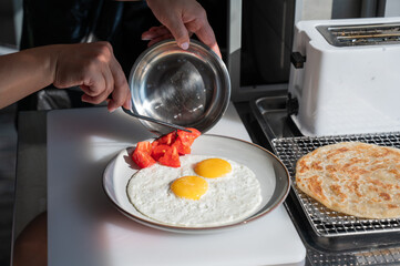 Chef serves fried eggs in a cafe. 