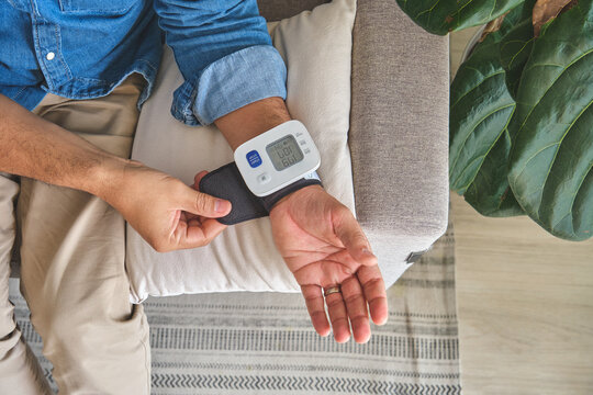 Person checking cardiovascular health with a digital blood pressure monitor on wrist