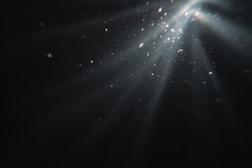Abstract light rays shining through darkness with particles in the background.