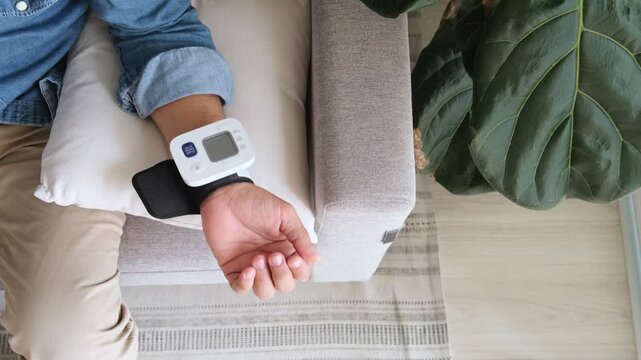 Man using a digital tonometer on his wrist to check his blood pressure and heart rate