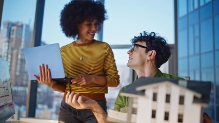 Property managers discussing model building at office closeup. Man explaining