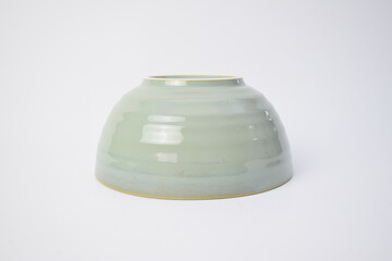 Upside down green ceramic bowl with ribbed texture isolated on white background