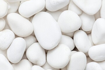 A close-up view of smooth, white pebbles arranged in a soft, natural pattern.