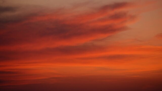 Sunset clouds creating a gradient of fiery red, orange, and golden hues across the sky