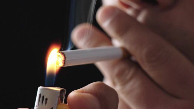Lighting up smoking cigarettes,Closeup of young man smoking a cigarette