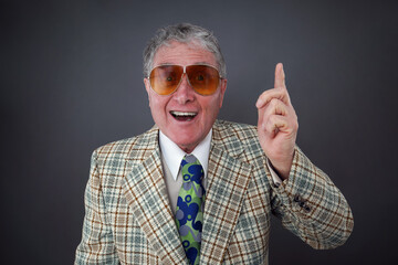 1970's business man in a retro plaid suit jacket gesturing that he has an idea