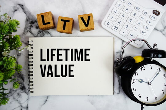 LTV Lifetime Value text with calculator and alarm clock on marble background