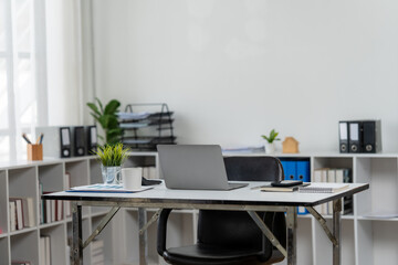 Minimalist Workspace Design: A contemporary office space featuring a desk, laptop, plants, stationery, and a comfortable chair, creating a conducive environment for productivity and focused work.