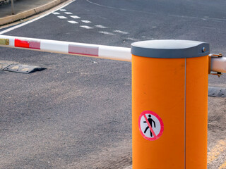 Barrier gate at parking entrance with orange control column