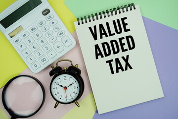 Value Added Tax text with calculator, alarm clock and magnifying glass