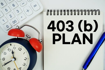 403B Plan text written on notepad with alarm clock and calculator on white background