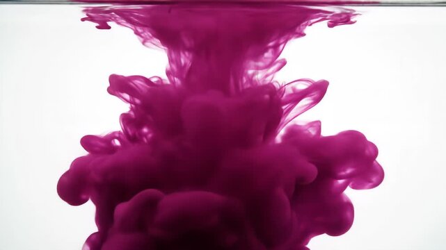 Vibrant crimson ink dissolving in water, forming intricate, smoke-like plumes and swirling patterns against a bright white background.
