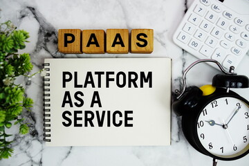 PaaS Platform as a Service text with calculator and alarm clock on marble background