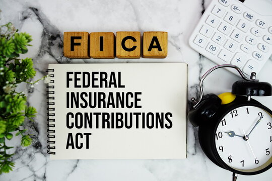 FICA Federal Insurance Contributions Act text with calculator and alarm clock on marble background