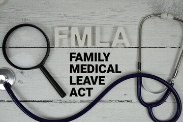 FMLA Family Medical Leave Act text with Stethoscope on wooden background
