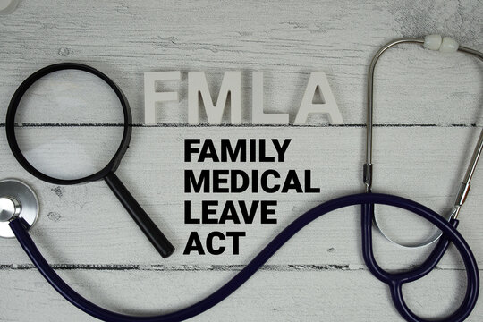 FMLA Family Medical Leave Act text with Stethoscope on wooden background
